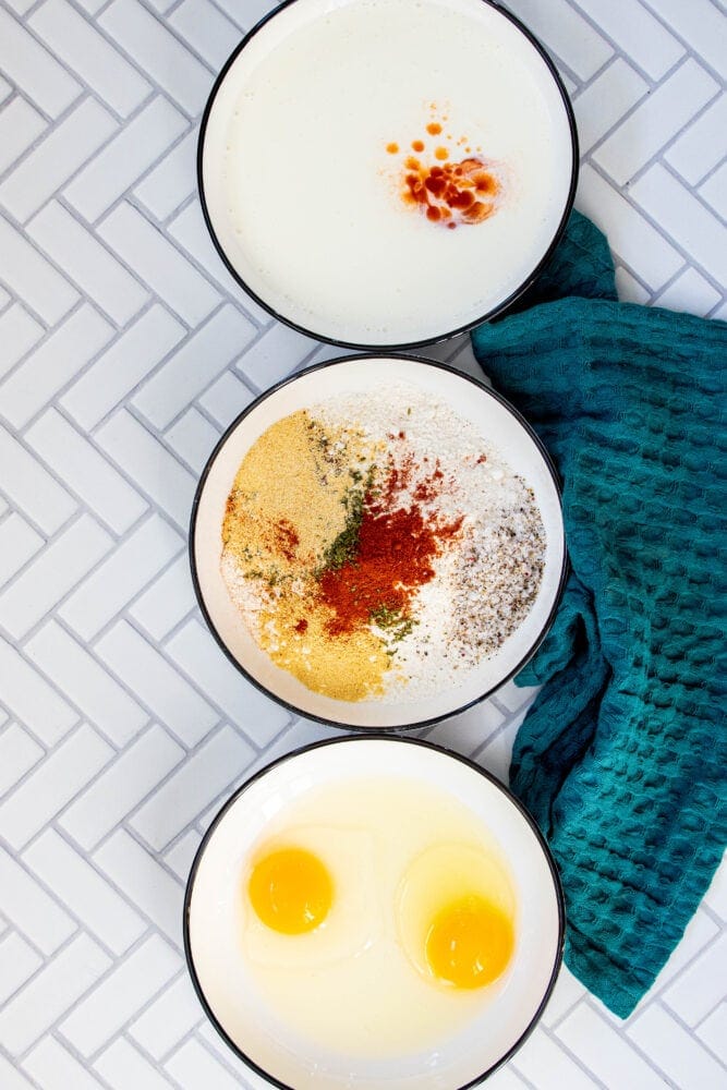 picture of bowls on a table with milk, eggs, and flour in them