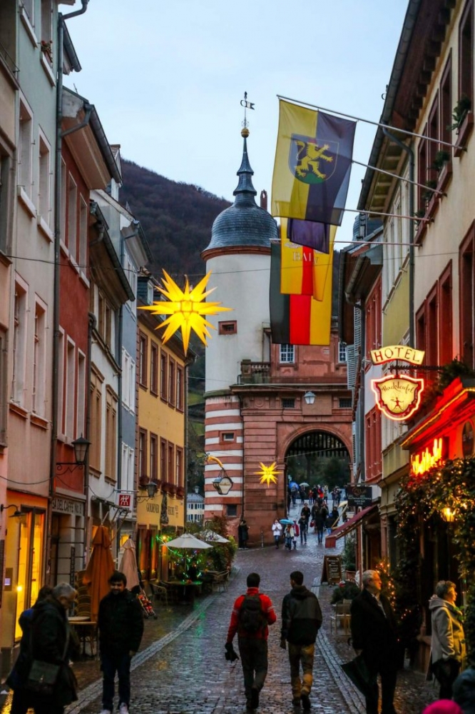 A group walking down a cobblestone street in Heidelberg during Christmas.