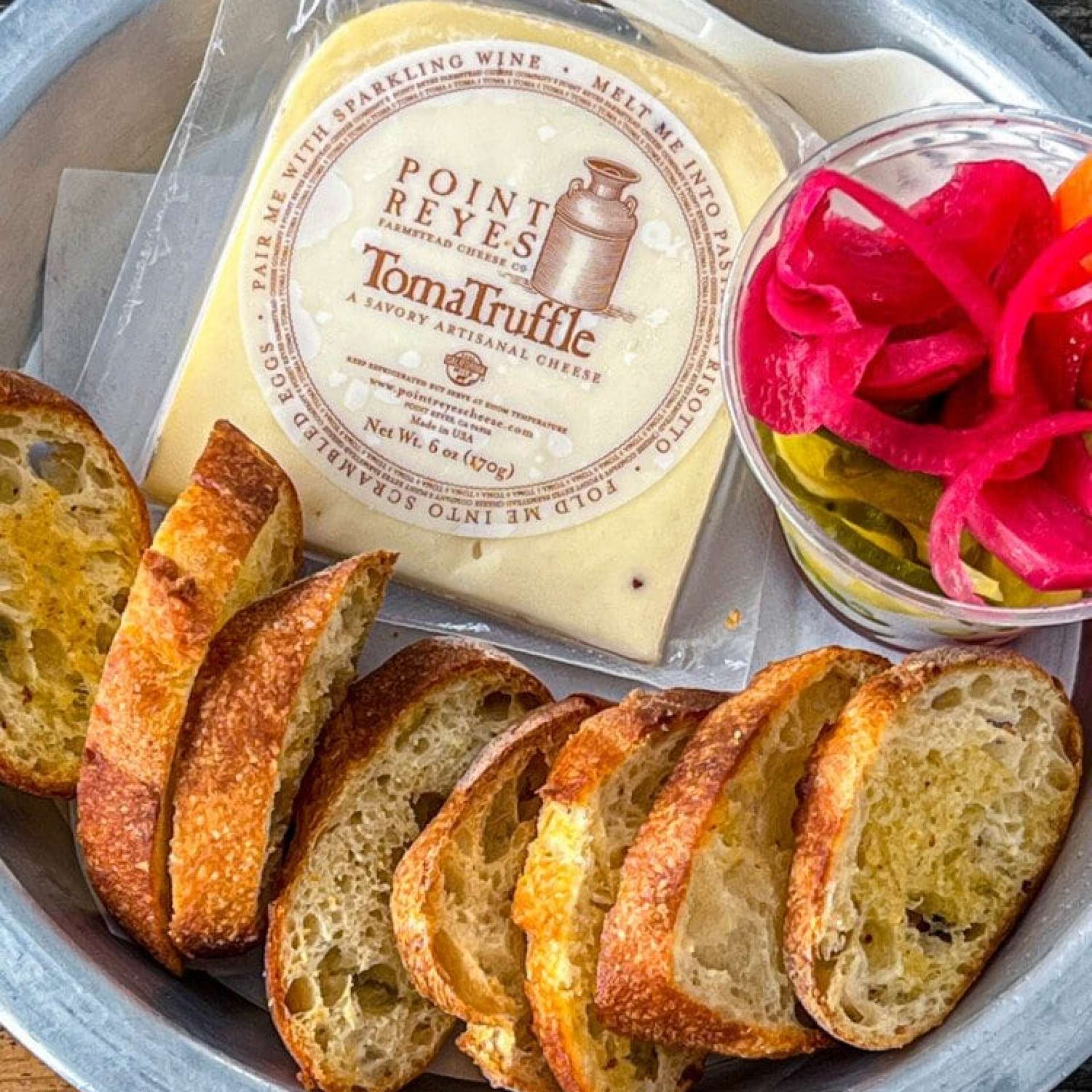 picture of toma truffle cheese in a metal plate at marshall store
